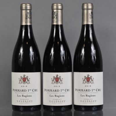 three bottles of red wine are lined up on a table