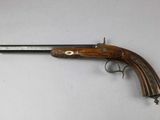 an old gun with a wooden handle on a white surface