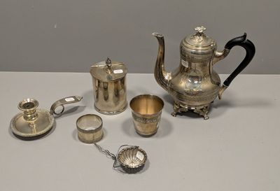 un service à thé en argent posé sur une table, à côté d'autres objets en argent