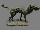 statue of a dog on a rock on a gray background