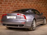 a silver car parked in front of a brick wall
