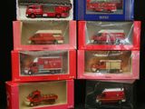 quatre camions de pompiers rouges et blancs sont représentés dans des cadres posés sur une surface noire