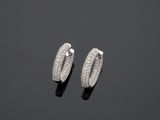 une paire de boucles d'oreilles créoles en or blanc et diamants