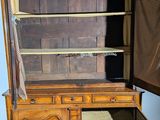 an old wooden cabinet with a glass door open