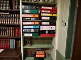 a book shelf with many books on it in the corner of a room