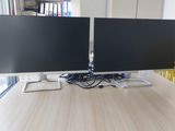 deux écrans d'ordinateur posés sur un bureau en bois