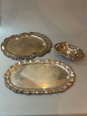 trois plateaux en argent posés les uns à côté des autres sur une table