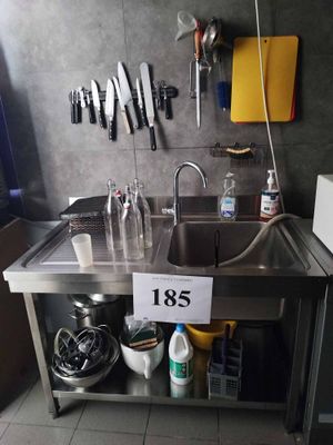 a kitchen with a sink and a lot of utensils hanging on the wall