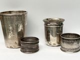 quatre tasses en argent posées les unes à côté des autres sur une surface blanche