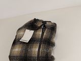 a close up of a sweater on a table with a tag on it