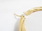 yellow gold hoop earrings on a white surface with a white background