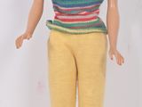 poupée Barbie aux cheveux blonds, vêtue d'un t-shirt rayé et d'un pantalon jaune