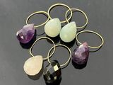 a bunch of rings with different colored stones on a black surface