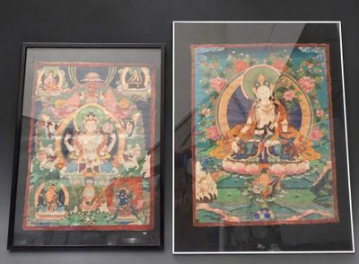 deux tableaux représentant des bouddhas, encadrés et exposés dans une vitrine