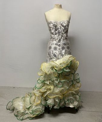 yellow and green ruffled dress on mannequin with white wall in background