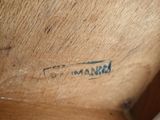 an image of a close up of a wooden chair with writing on the seat