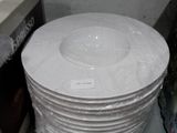 a stack of white plates sitting on top of a microwave