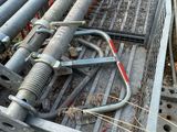 a pile of metal pipes on the ground next to a fence