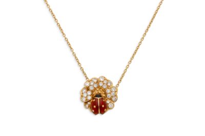 un collier en or orné d'une coccinelle rouge et blanche