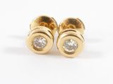 une paire de boucles d'oreilles à clous en or jaune et diamants sur fond blanc