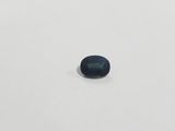 a blue sapphire stone on a white surface