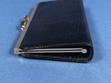black leather wallet with a chain on a blue surface