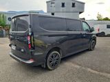a black van parked in a parking lot near a building