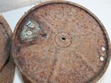 an old rusty drum sitting on the floor next to an old one