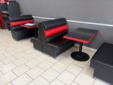 une banquette rouge et noire avec deux chaises et une table