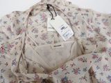 the shirt has a floral pattern on it and a white tag on it
