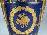 a blue vase with a gold decoration on it