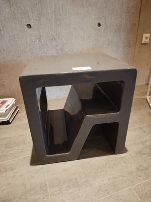 une petite table noire sur laquelle se trouve un porte-revues