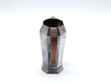 a silver vase with a wooden handle on a white surface