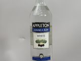 a bottle of white wine sitting on top of a wooden stand