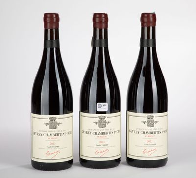 three bottles of wine are lined up on a white surface