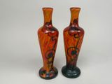 une paire de vases orange et noirs sur fond blanc