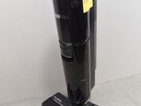 the black vacuum is sitting on the floor next to the wall