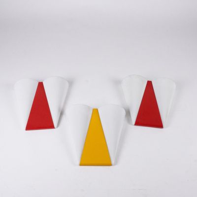 three red and yellow triangulars sitting on top of a white surface