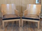 two wooden chairs that are sitting on a wooden floor