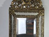 un petit miroir posé sur une table devant un mur blanc