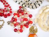 many different colored beads and necklaces on a white surface