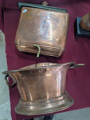 trois casseroles et poêles en cuivre exposées sur une table