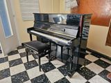 a piano and a stool in a room with a checkered floor