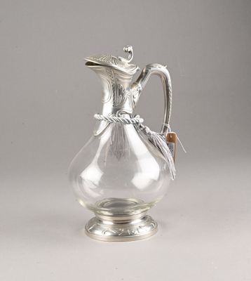 a glass pitcher with a bird on it on a table