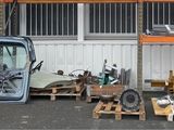 un camion garé devant un bâtiment, chargé de nombreuses palettes