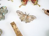 many different types of brooches on a white table