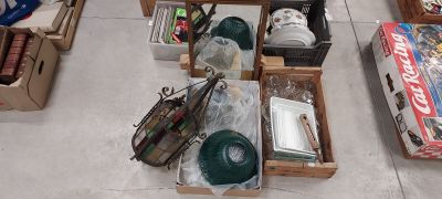 Plusieurs cartons contenant des objets divers sont posés par terre dans une pièce.