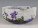 a white bowl with purple flowers painted on it