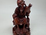 an image of a statue of a man with a goat on a rock