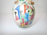 a vase with a painting on it sitting on a table